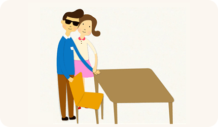 시각장애인의 손이 의자 등받이와 책상에 닿게 하여 스스로 위치를 파악하고 앉을 수 있게 돕는 이미지